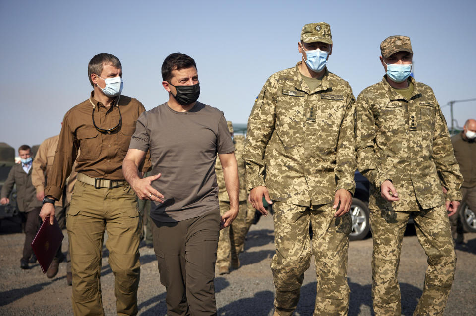 FILE In this file photo taken on Saturday, Sept. 26, 2020, Ukrainian President Volodymyr Zelenskiy, second left, surrounded by servicemen as he visits the war-hit Donetsk region, eastern Ukraine. Ukrainians are heading to the polls on Sunday, Oct. 25, 2020 to cast ballots in local elections seen as a key test for President Volodymyr Zelenskiy. Zelenskiy, a popular comedian without prior political experience, was elected by a landslide in April 2019 on promises to end fighting with Russia-backed separatists in eastern Ukraine, uproot endemic corruption and shore up a worsening economy.(Ukrainian Presidential Press Office via AP, File)