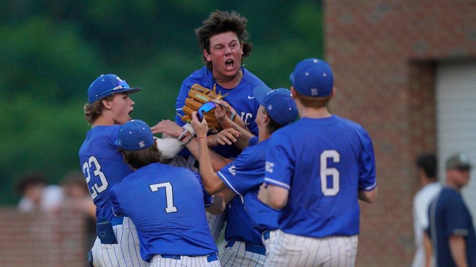 Teammates swarm closer Jack Sams after winning the 11th Regional baseball championship game over Great Crossing at Madison Central High School.