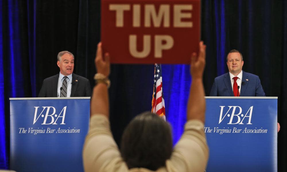 A time keeper holds a sign as Tim Kaine, left, and Republican challenger Corey Stewart, right, debate in Hot Springs, Virginia.