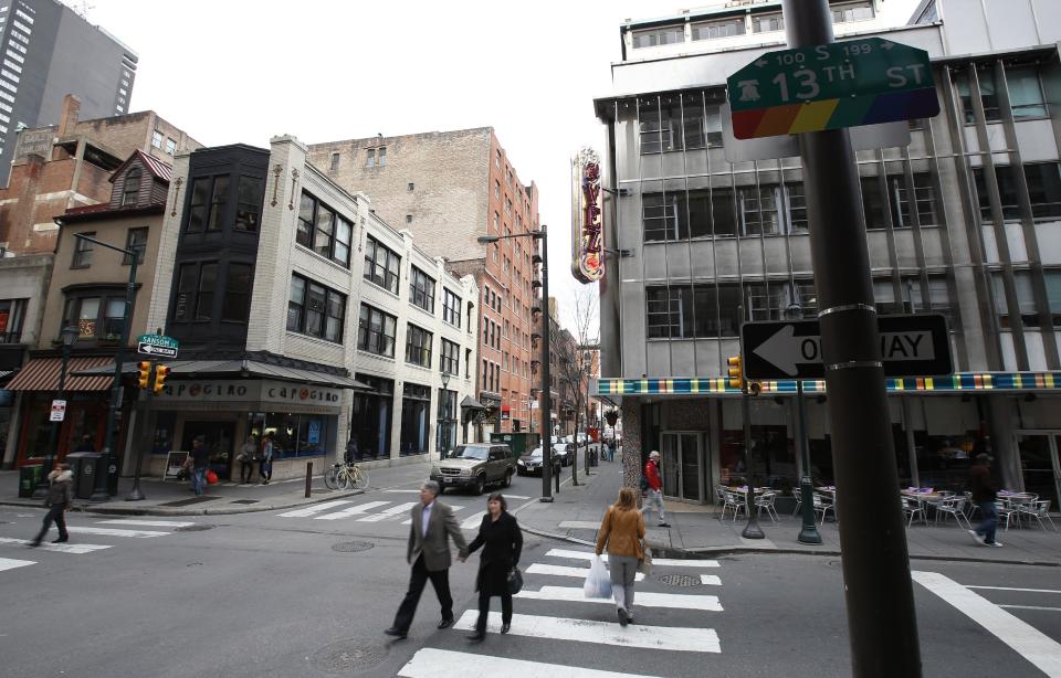 In this Tuesday, April 1, 2014 photo, pedestrians cross 13th Street near El Vez, a gregarious Mexican restaurant, and Capogiro gelato in Philadelphia. Tourism officials will tell you the restaurant-rich area in the heart of downtown is called Midtown Village, but that moniker hasn't entirely caught on with locals. Philadelphia food lovers just know 13th Street as a vibrant area chock full of great eateries and wine bars. (AP Photo/Matt Slocum)