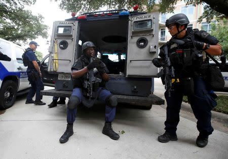 Dallas police SWAT team members stay in a holding position in front of the Dallas Police Department headquarters which was locked down after an anonymous threat was reported in Dallas, Texas, U.S. July 9, 2016. REUTERS/Carlo Allegri