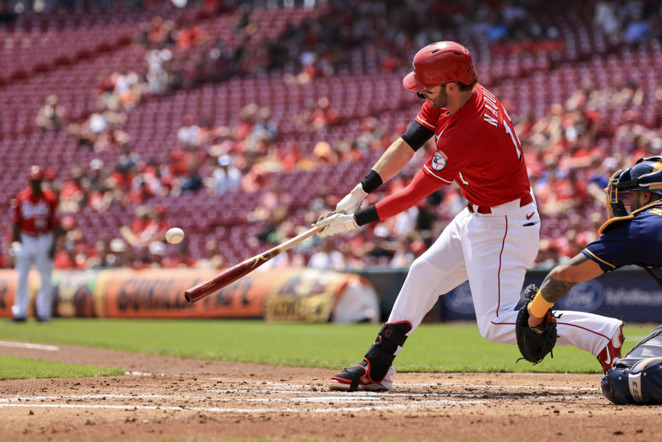 Cincinnati Reds' Tyler Naquin hits a three-run triple during the first inning of a baseball game against the Milwaukee Brewers in Cincinnati, Wednesday, May 11, 2022. (AP Photo/Aaron Doster)