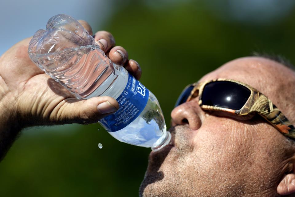 FILE - Robert Harris drinks water while taking a break from digging fence post holes, Tuesday, June 27, 2023, in Houston. As the heat breaks records, weakening and sickening people, it’s worth remembering that dire heat waves have inspired effective efforts to prevent heat illness. (AP Photo/David J. Phillip, File)