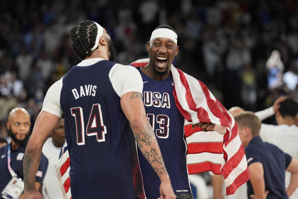 USA's Anthony Davis (14) and Bam Adebayo (13) celebrate after defeating France to win the gold medal during a men's basketball gold medal game at Bercy Arena at the 2024 Summer Olympics, Saturday, Aug. 10, 2024, in Paris, France. (AP Photo/Rebecca Blackwell)