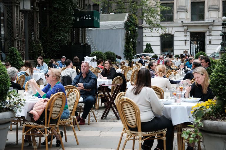 En Bryant Park, Manhattan, la gente disfruta de restaurantes en mesas al aire libre