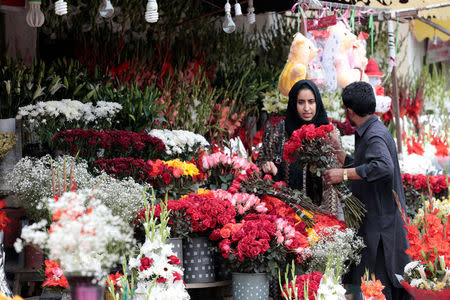 A woman buys flowers at a flower market in Islamabad, Pakistan February 14, 2017. REUTERS/Caren Firouz