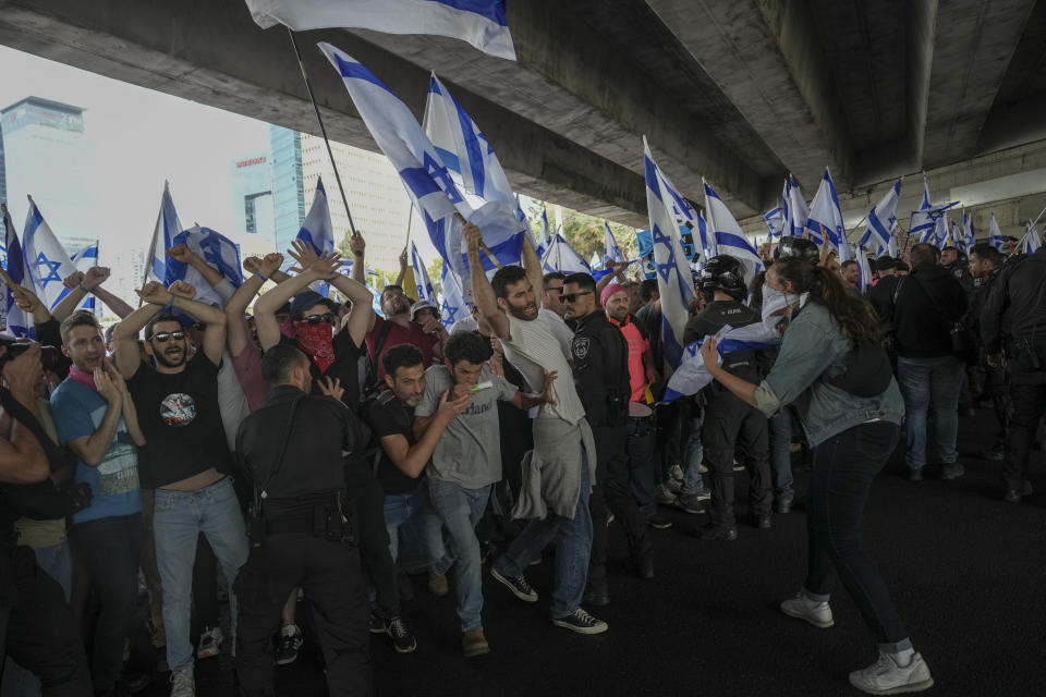 Israeli police try to block Israelis protesting against plans by Prime Minister Benjamin Netanyahu's government to overhaul the judicial system to reach the free way in Tel Aviv, Israel, Thursday, March 23, 2023. (AP Photo/Oded Balilty)