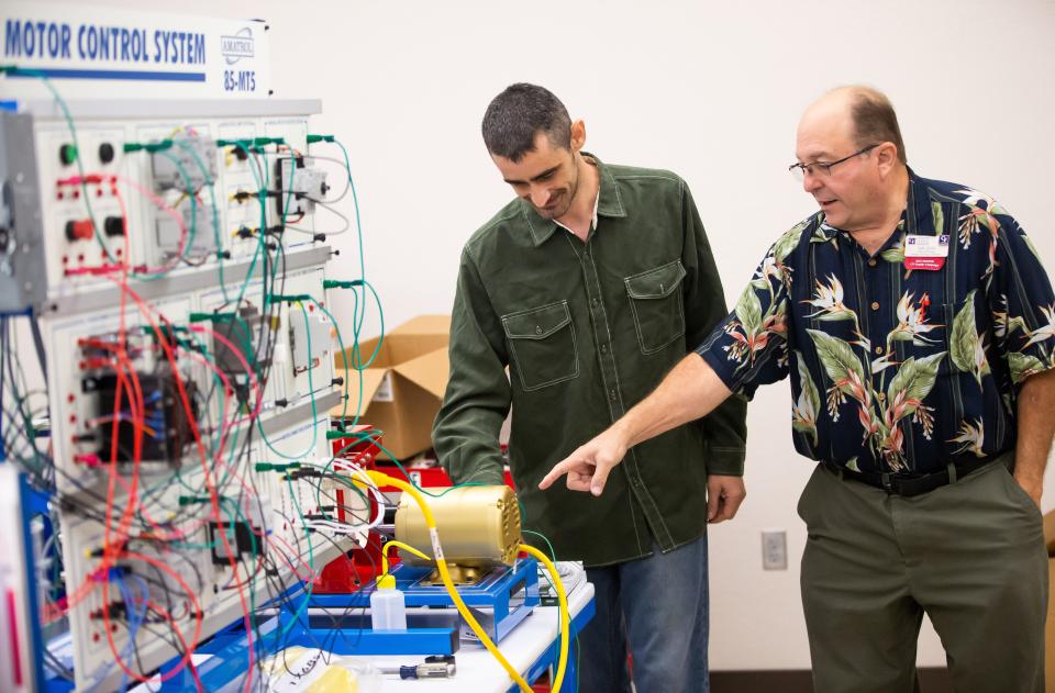 Sam Ajlani, associate professor and program manager of engineering technology at the College of Central Florida, right, works with Teaching Assistant Chris Kromke, left, in the engineering lab at the College of Central Florida on Oct. 18.