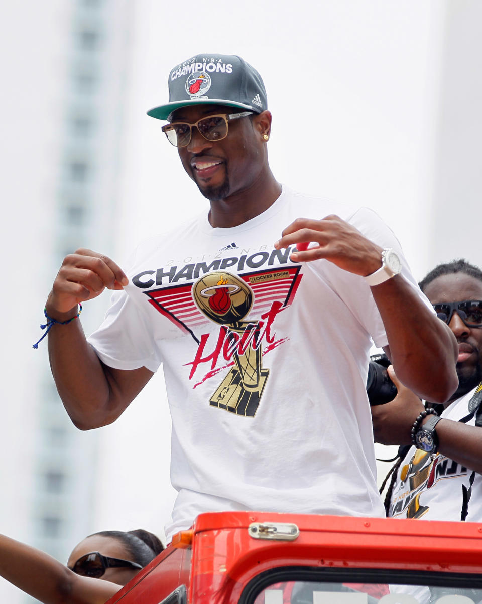 MIAMI, FL - JUNE 25: Dwyane Wade of the Miami Heat shows off his championship t-shirt as he rides in a victory parade through the streets during a celebration for the 2012 NBA Champion Miami Heat on June 25, 2012 in Miami, Florida. The Heat beat the Oklahoma Thunder to win the NBA title. (Photo by Joe Raedle/Getty Images)