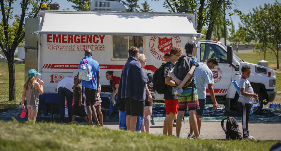 People crowd around an emergency services vehicle.