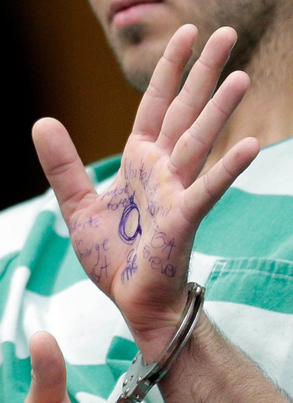 Anthony Comello displays writing on his hand during his extradition hearing in Toms River, N.J., Monday, March 18, 2019. (AP Photo/Seth Wenig)