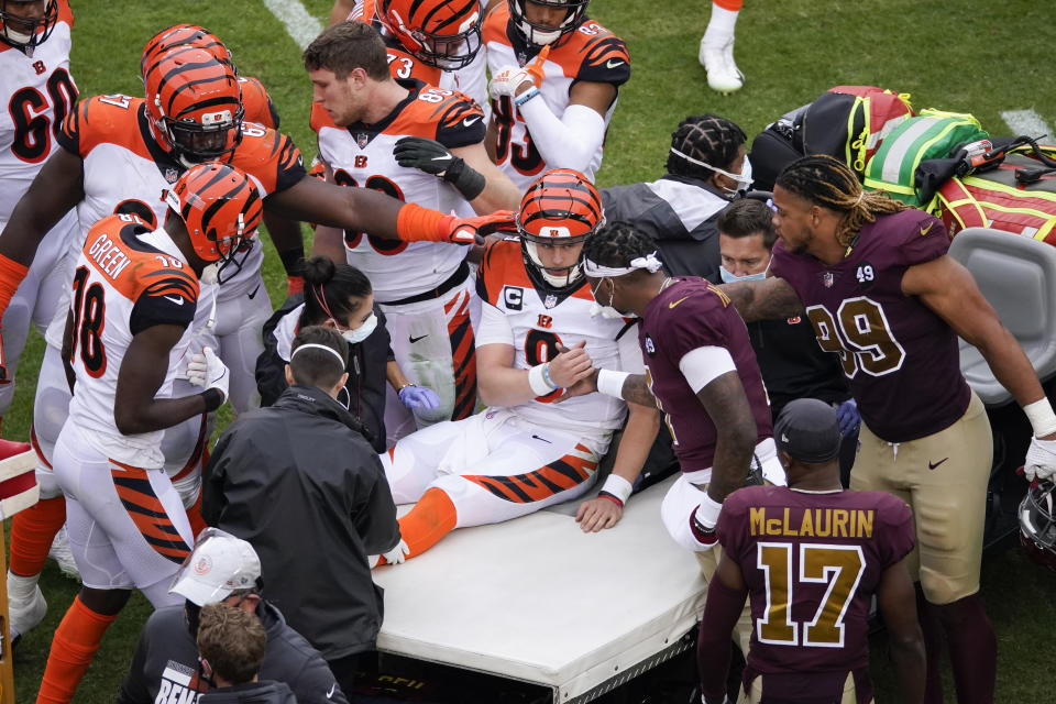 Cincinnati Bengals quarterback Joe Burrow (9) shakes hands with Washington Football Team quarterback Dwayne Haskins (7) as Burrows is carted away off the field during the second half of an NFL football game, Sunday, Nov. 22, 2020, in Landover. Burrows left the game with a left knee injury. (AP Photo/Al Drago)