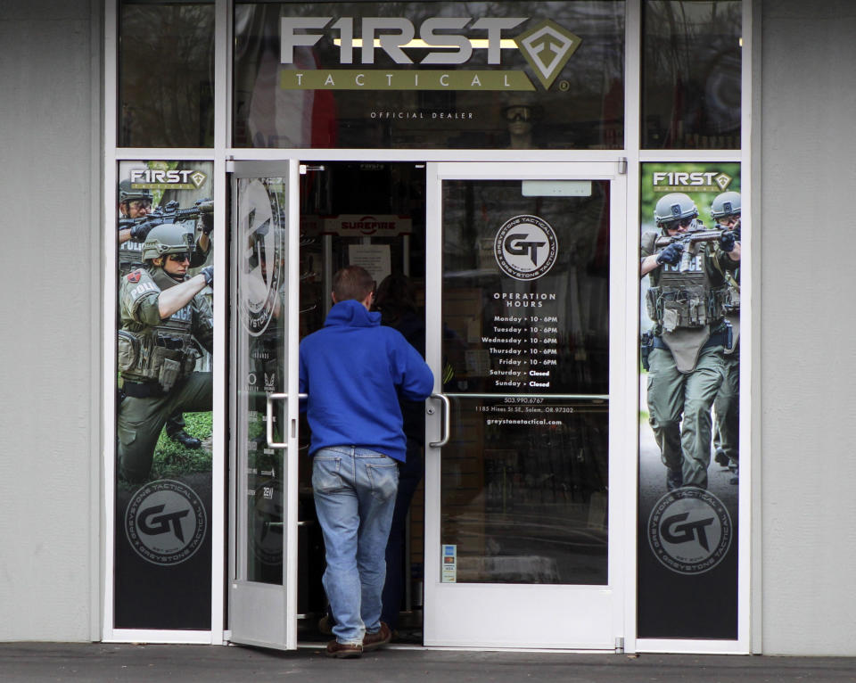 FILE - In this Feb. 19, 2021, file photo, a man enters a gun shop in Salem, Ore. The first legal test of whether a wave of U.S. counties can legally declare themselves "Second Amendment Sanctuaries," and refuse to enforce certain gun laws is playing out in a rural Oregon logging county. The measure Columbia County voters narrowly approved last year bans local officials from enforcing most federal and state gun laws, which includes things like universal background checks or any prohibition on carrying guns. (AP Photo/Andrew Selsky, File)