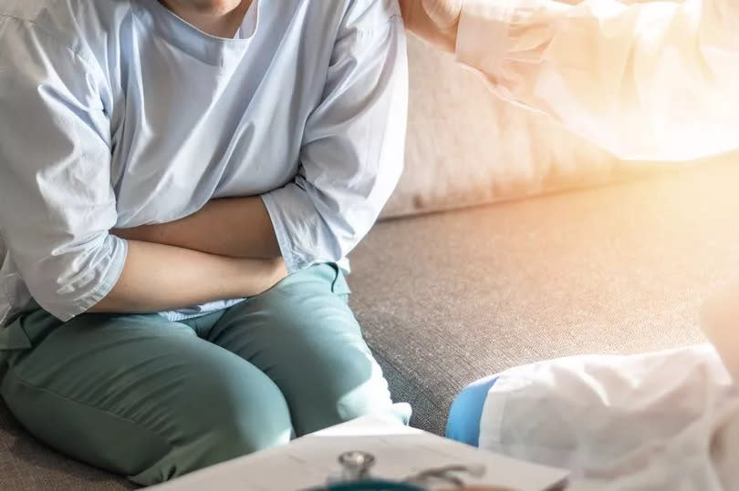 Abdominal pain patient woman having medical exam with doctor on illness from stomach cancer, irritable bowel syndrome, pelvic discomfort, Indigestion, Diarrhea, GERD (gastro-esophageal reflux disease)