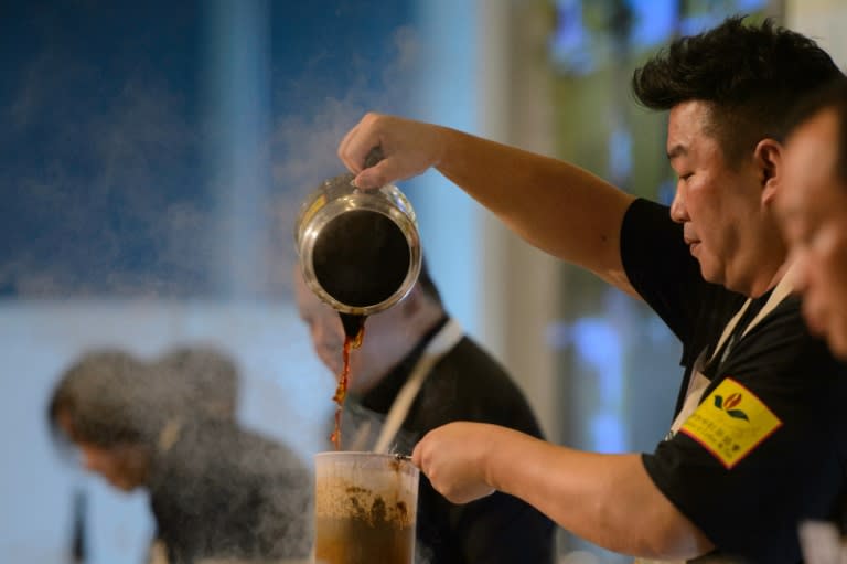 Shanghai regional tea-making champion Liang Yuan-hui pours his brew during the Hong Kong Style Milk Tea international final held during the 2016 Hong Kong International Tea Fair on August 13, 2016