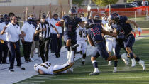 Herriman's Brock Hollingsworth (5) hurdles Jackson Leaver (11) during a high school football game, on Thursday, Aug. 13, 2020, in Herriman, Utah. Utah is among the states going forward with high school football this fall despite concerns about the ongoing COVID-19 pandemic that led other states and many college football conferences to postpone games in hopes of instead playing in the spring. (AP Photo/Rick Bowmer)