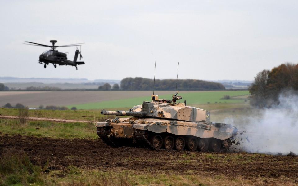 SALISBURY, ENGLAND - OCTOBER 29: An Apache attack helicopter and a Challenger 2 battle tank in action as the British Army demonstrate the latest and future technology used on operations across the globe on Salisbury plain training area on October 29, 2019 in Salisbury, England. (Photo by Finnbarr Webster/Getty Images) - Finnbarr Webster/GETTY IMAGES