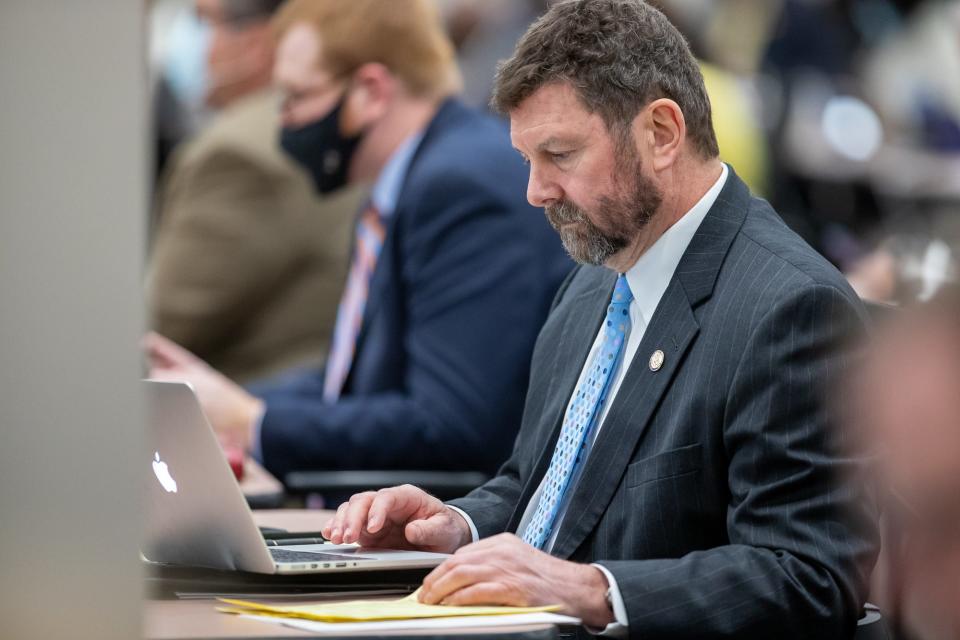 Rep. Jim Lucas looks at documents on his computer while at his desk as the Indiana House meets on Monday, Feb. 8, 2021, inside the temporary chamber at the Government Center South in Indianapolis.