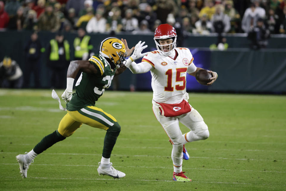 Kansas City Chiefs quarterback Patrick Mahomes (15) stiff arms Green Bay Packers cornerback Corey Ballentine (35) during the first half of an NFL football game Sunday, Dec. 3, 2023 in Green Bay, Wis. (AP Photo/Mike Roemer)