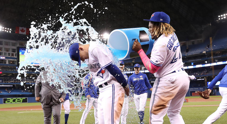 Vladimir Guerrero Jr., right, douses Cavan Biggio after a victory. (Tom Szczerbowski/Getty Images)