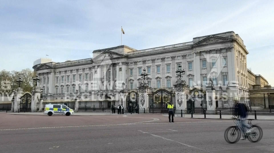 This image from a video shows police officers standing outside Buckingham Palace, where a man was arrested late Tuesday on suspicion of possessing an offensive weapon, London police said, in London, Tuesday, May 2, 2023. (CHANNEL 7 via AP)