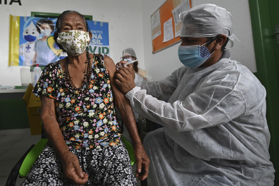 A woman of the Ticuna Indigenous group gets her shot of the COVID-19 vaccine produced by China's Sinovac Biotech Ltd, during the start of the vaccination plan on indigenous lands at the Ticuna de Umariaçu village health post in Tabatinga, Amazonas state, Brazil, Tuesday, Jan. 19, 2021. (AP Photo/Andre Borges)