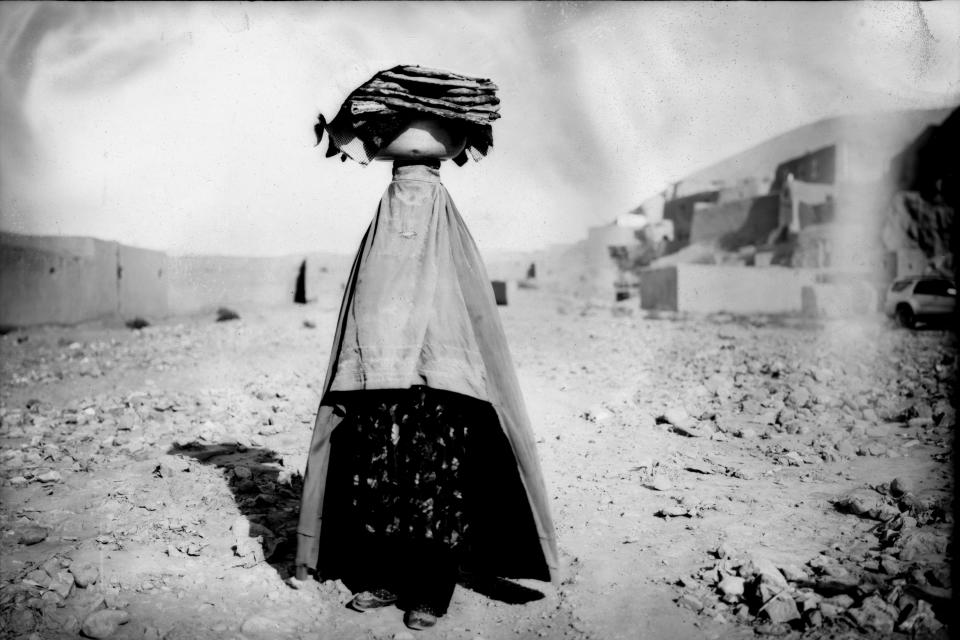 A woman in a burqa walks home carrying bread for her family and neighbors in Bamiyan, Afghanistan, June 18, 2023 (AP Photo/Rodrigo Abd)