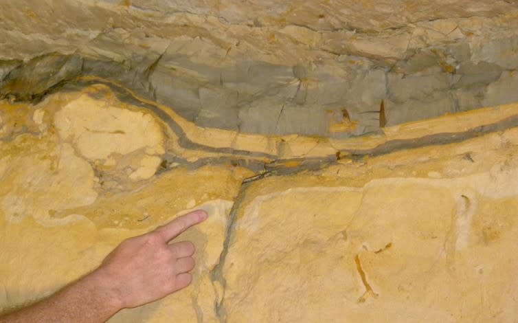 <span class="caption">Cretaceous-Paleogene clay layer (gray) in the Geulhemmergroeve tunnels in the Netherlands. Finger is on the actual K–Pg boundary.</span>