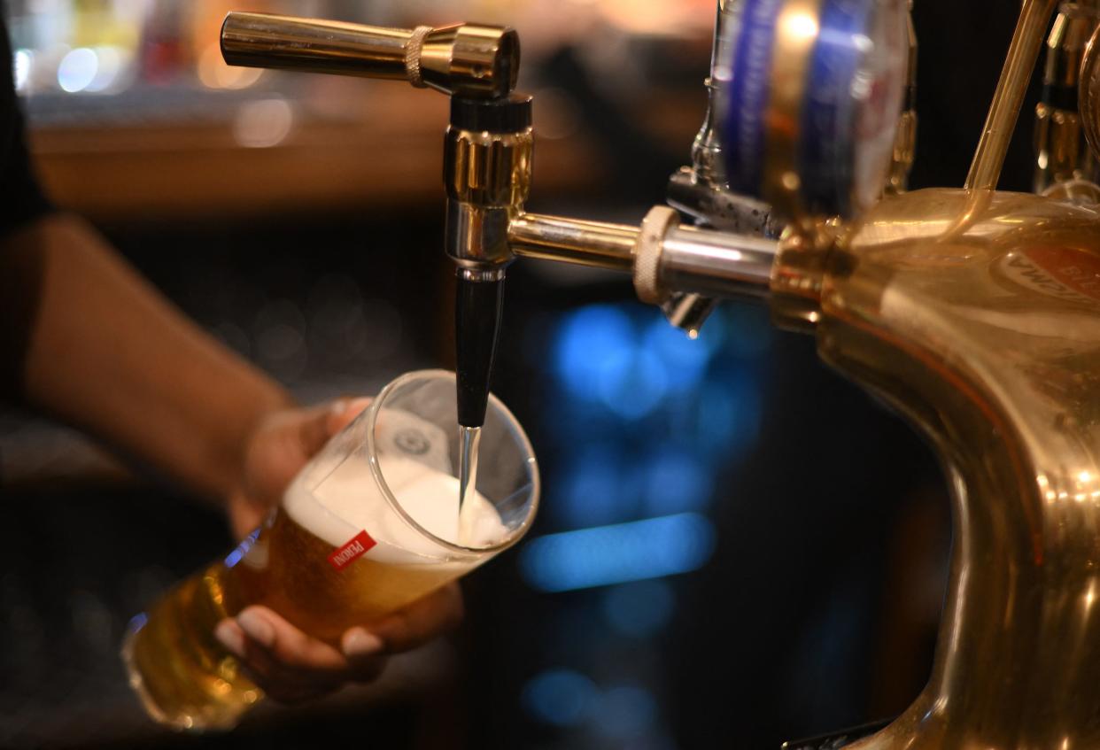 JD Wetherspoon An employee pours a pint of Peroni beer on at the bar in the Mad Hatter pub and hotel, operated by Fuller's, in London on November 30, 2022. At The Mad Hatter pub, everything is ready: the huge Christmas tree, the luminous and golden garlands. On the bar sits signs that read: 