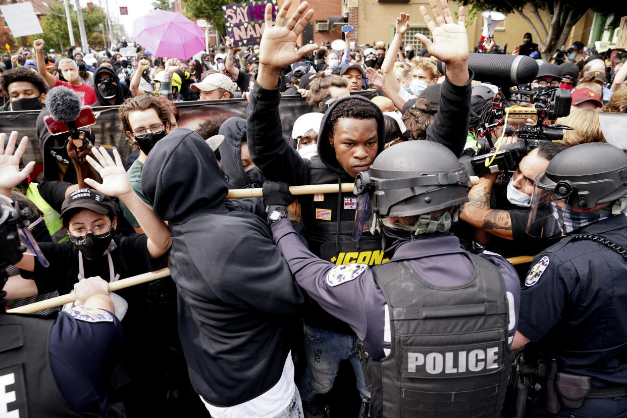 FILE - Police and protesters converge during a demonstration, Wednesday, Sept. 23, 2020, in Louisville, Ky. Recent revelations about the search warrant that led to Breonna Taylor’s death have reopened old wounds in Louisville’s Black community and disrupted the city’s efforts to restore trust in the police department. (AP Photo/John Minchillo, File)