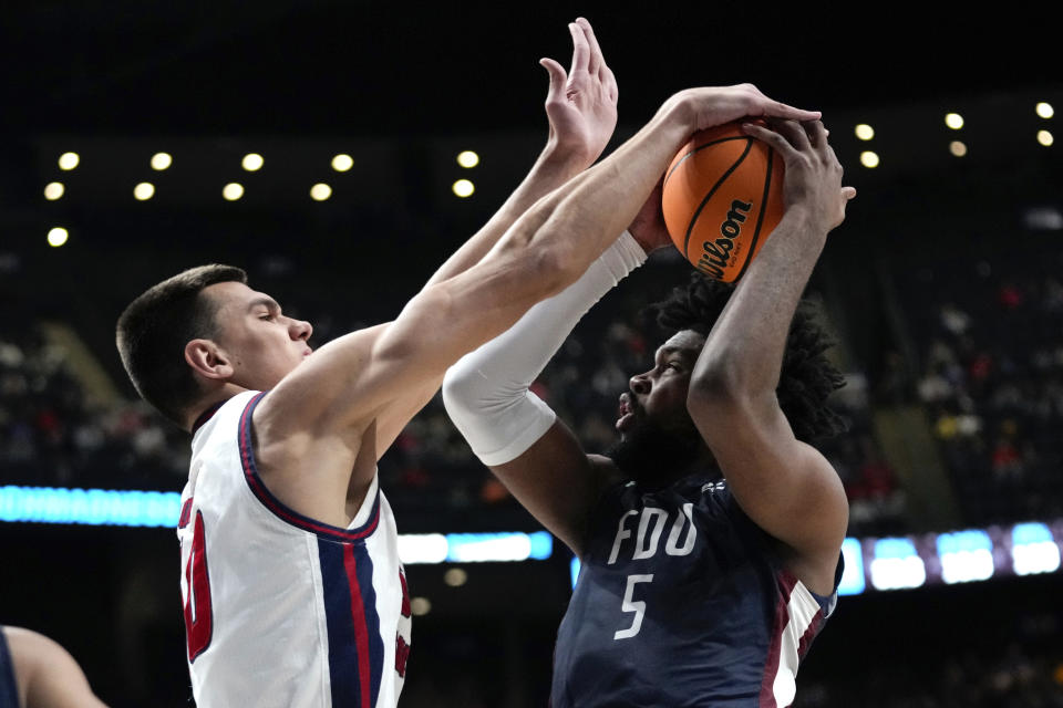 Florida Atlantic center Vladislav Goldin (50) blocks Fairleigh Dickinson forward Ansley Almonor (5) in the second half of a second-round men's college basketball game in the NCAA Tournament Sunday, March 19, 2023, in Columbus, Ohio. (AP Photo/Paul Sancya)