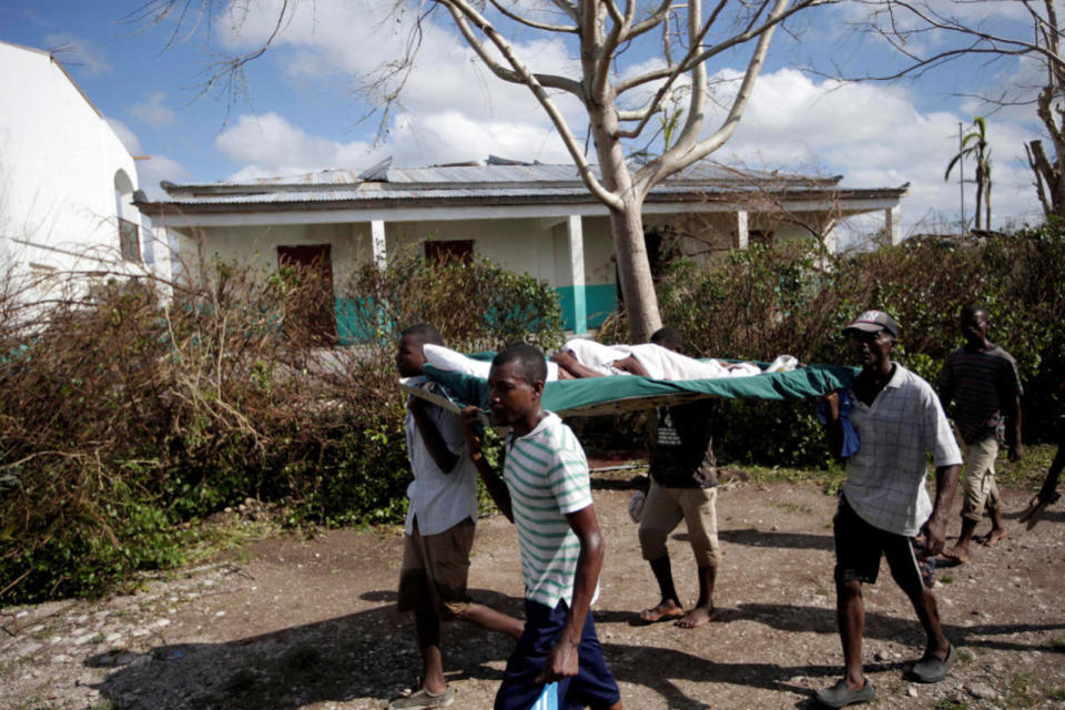 <p>Men carry a woman wounded in Hurricane Matthew in Chantal, Haiti October 7, 2016. (REUTERS/Andres Martinez Casares)</p>