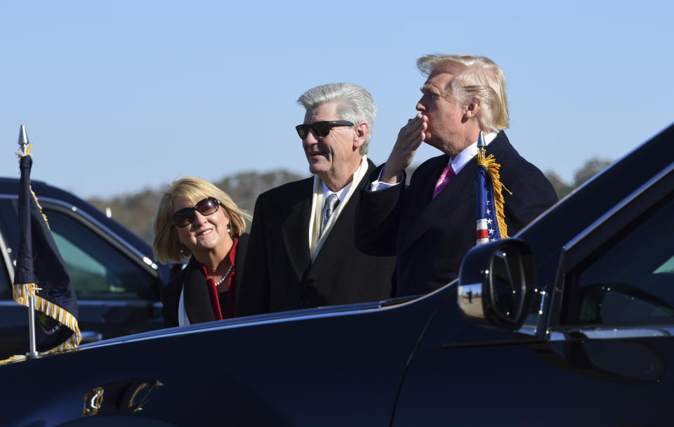 <p>President Donald Trump, right, standing with Mississippi Gov. Phil Bryant, center, blows a kiss to the crowd after arriving on Air Force One at Jackson-Medgar Wiley Evers International Airport in Jackson, Miss., Saturday, Dec. 9, 2017. (Photo: Susan Walsh/AP) </p>