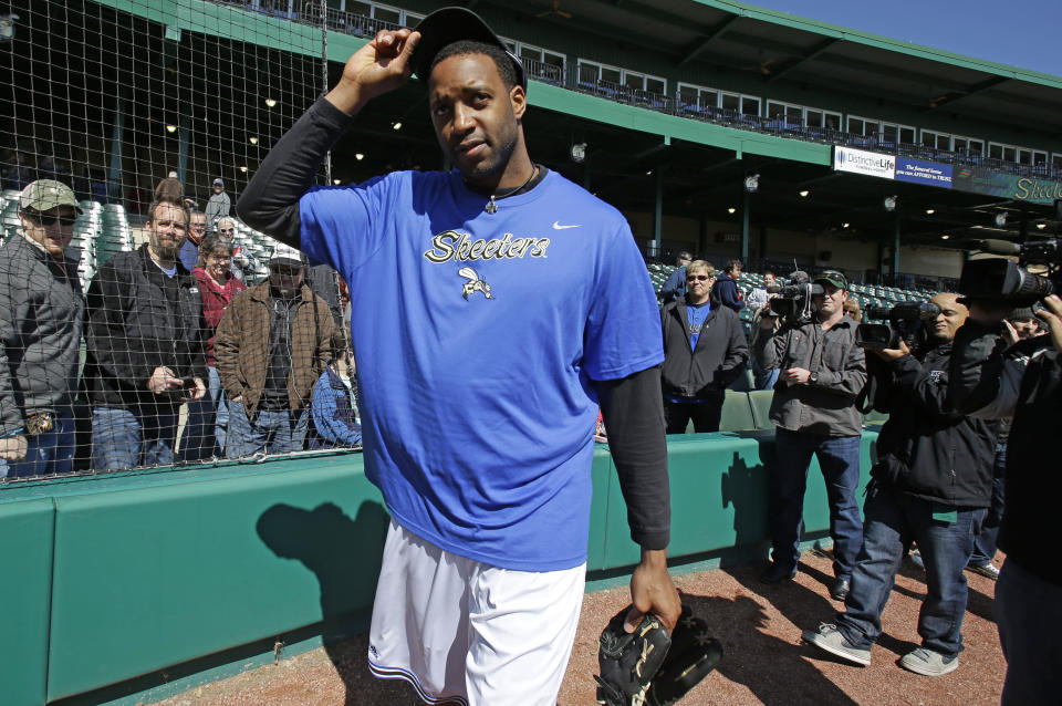 Followed by cameras former NBA All-Star Tracy McGrady removes his cap after a pitching workout at the Sugar Land Skeeters baseball stadium Wednesday, Feb. 12, 2014, in Sugar Land, Texas. McGrady hopes to try out as a pitcher for the independent Atlantic League Skeeters. (AP Photo/Pat Sullivan)