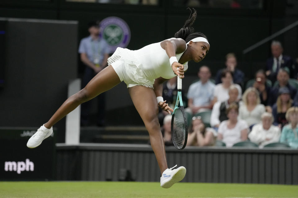 Coco Gauff of the US serves to Romania's Mihaela Buzarnescu in a second round women's singles match on day four of the Wimbledon tennis championships in London, Thursday, June 30, 2022. (AP Photo/Kirsty Wigglesworth)
