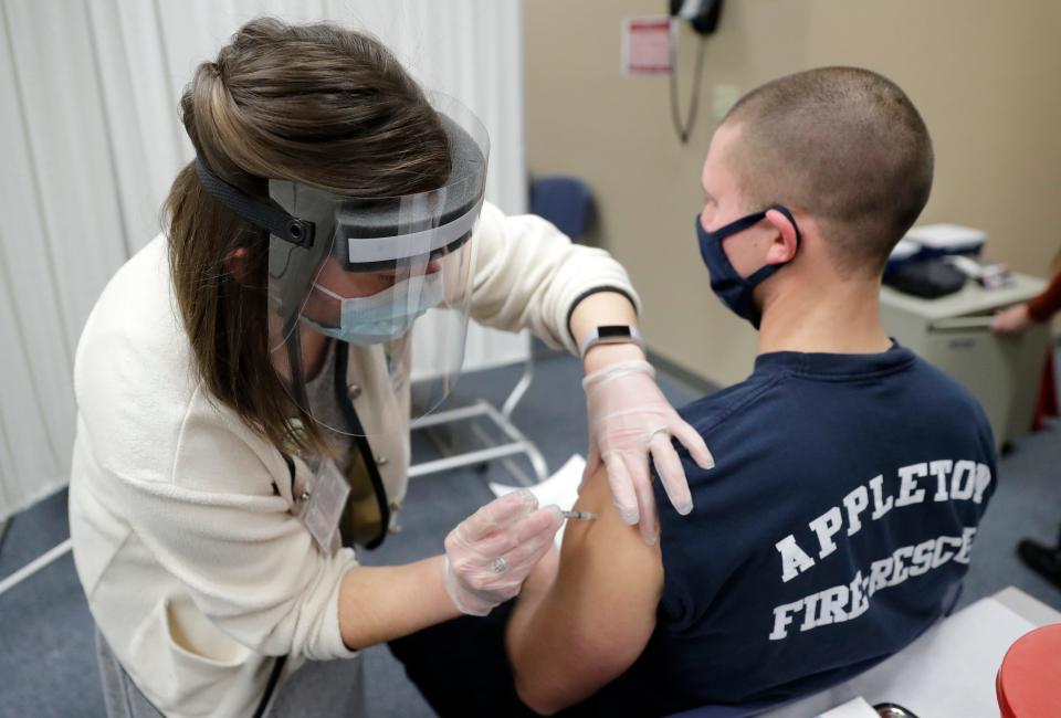 Public health nurse Jess Moyle administers the Pfizer COVID-19 vaccine to firefighter Bryce Sternhagen on Tuesday, Jan. 12, 2021, at City Hall in downtown Appleton, Wis.