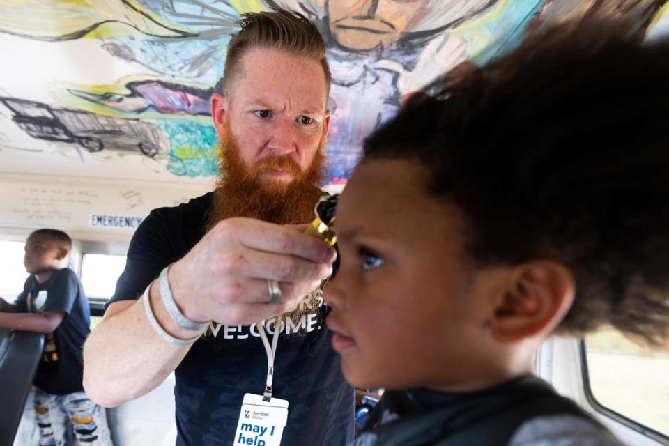 Jordan Allsup with CleanUP give a haircut to Ja’Liyah Rhodes, 5, on a bus converted to a barbershop Tuesday, Aug. 9, 2022, in Fort Worth. CleanUP hosts events throughout the area to offer free haircuts and clothing.