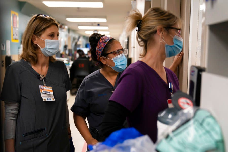Health care workers watch as medical workers try to resuscitate a patient who tested positive for coronavirus at Providence Holy Cross Medical Center in the Mission Hills area of Los Angeles. (AP Photo/Jae C. Hong, File)