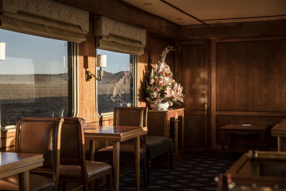 Flowers are seen in the observation car of the Blue Train as it rides through the semi-desert landscape of the Karoo, on February 26, 2021. - Forty-eight hours to stop thinking about anything, to let yourself be pampered, to play the princes and princesses. The Blue Train, the ultimate luxury travel train experience,  crosses South Africa for more than 1,400 km from Cape Town, its southern tip, to its capital Pretoria, through fields and slums, urban centres and dream landscapes. (Photo by MARCO LONGARI / AFP) (Photo by MARCO LONGARI/AFP via Getty Images)