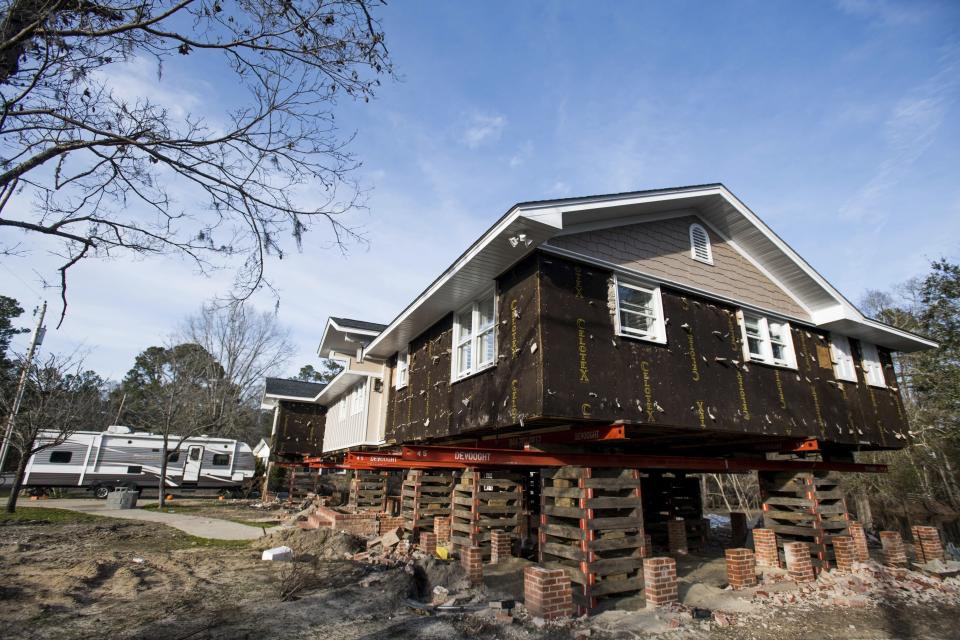 A travel camper sits in the driveway outside of a home in the process of being raised after being damaged by floodwaters from Hurricane Florence Friday, Feb. 1, 2019, in Conway, S.C. Multiple residents in the neighborhood near the Crabtree Swamp are currently living in campers as their homes are repaired. (AP Photo/Sean Rayford)