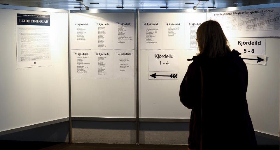 A woman reads instructions inside a polling station in Reykjavik, Iceland, Saturday, Sept. 25, 2021. Iceland is heading to the polls for general elections on Saturday with nine parties running for seats at the North Atlantic island nation's Parliament, or Althing. Polls suggest Prime Minister Katrin Jakobsdottir's Left Green Party could face a poor outcome, ending the current coalition. (AP Photo/Brynjar Gunnarsson)