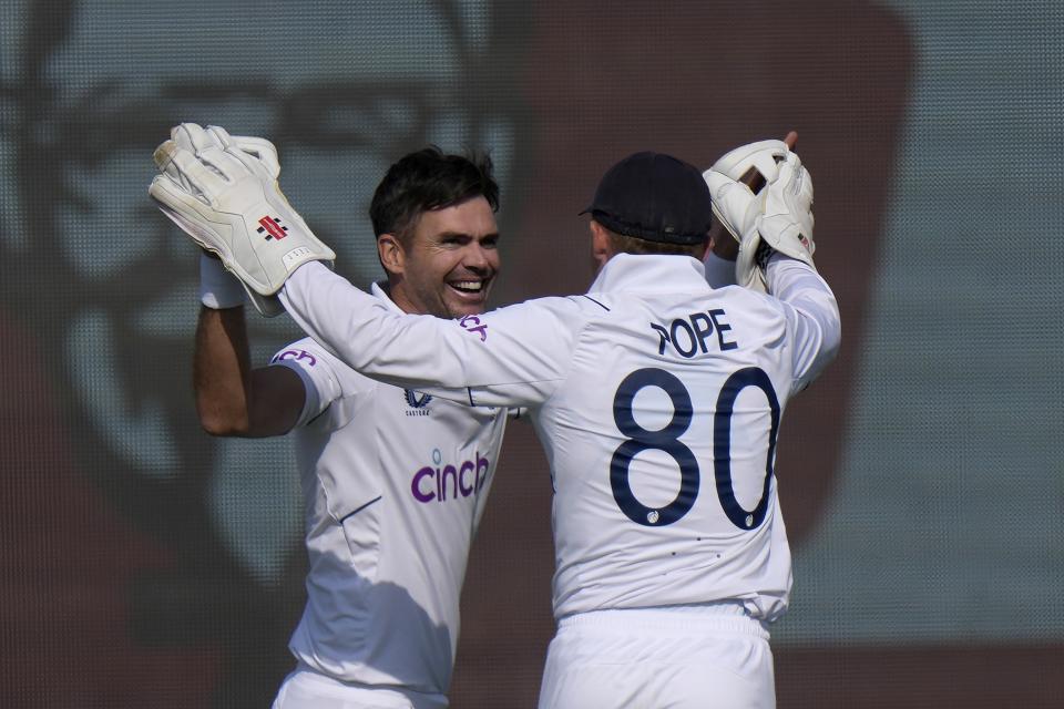England's Jame Anderson, left, celebrates with Ollie Pope after taking wicket of Pakistan's Muhammad Rizwan during the third day of the second test cricket match between Pakistan and England, in Multan, Pakistan, Sunday, Dec. 11, 2022. (AP Photo/Anjum Naveed)