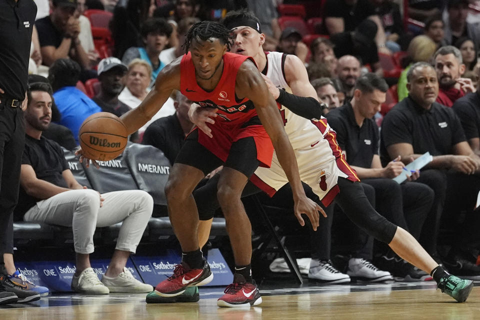 Toronto Raptors guard Immanuel Quickley (5) dribbles the ball as Miami Heat guard Tyler Herro (14) defends during the first half of an NBA basketball game, Friday, April 12, 2024, in Miami. (AP Photo/Marta Lavandier)