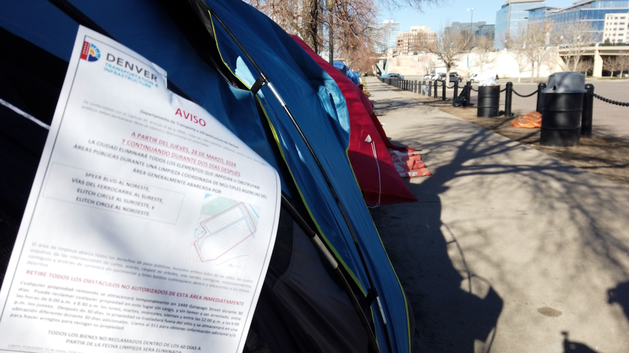 A notice is place on a tent at an encampment near Elitch Gardens giving migrants living there one week to leave.