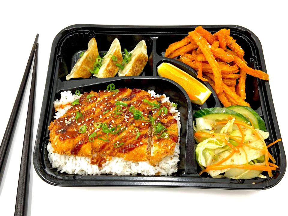 Bento box with chicken katsu, dumplings and sweet potato fries.