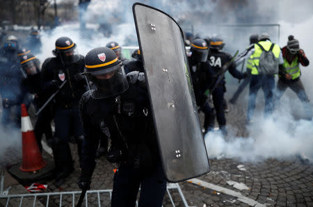 Protesters wearing yellow vest, a symbol of a French drivers' protest against higher fuel prices, clash with riot police on the the Champs-Elysee in Paris, France, November 24, 2018. REUTERS/Benoit Tessier