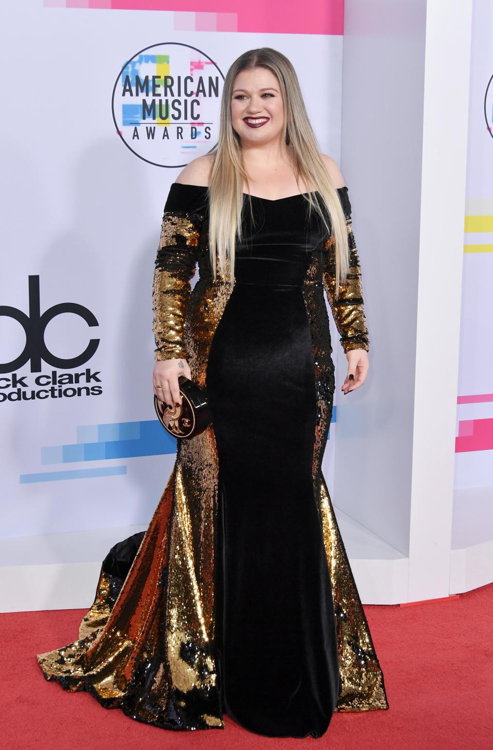 <p>Former American Idol star Kelly Clarkson kept it sultry in a black velvet and gold-sequinned gown.</p>