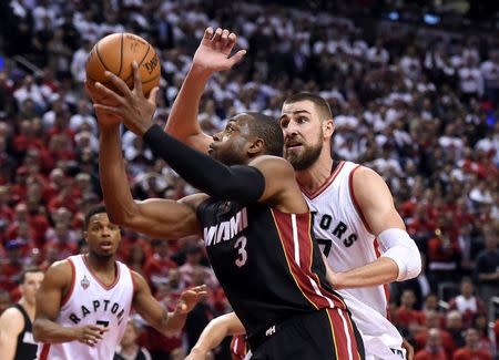 Miami Heat guard Dwyane Wade (3) shoots past Toronto Raptors guard Jonas Valanciunas (17) in game one of the second round of the NBA Playoffs at Air Canada Centre. The Heat won 102 -96 in overtime. Mandatory Credit: Dan Hamilton-USA TODAY Sports