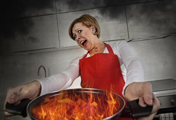 Woman holding pan on fire