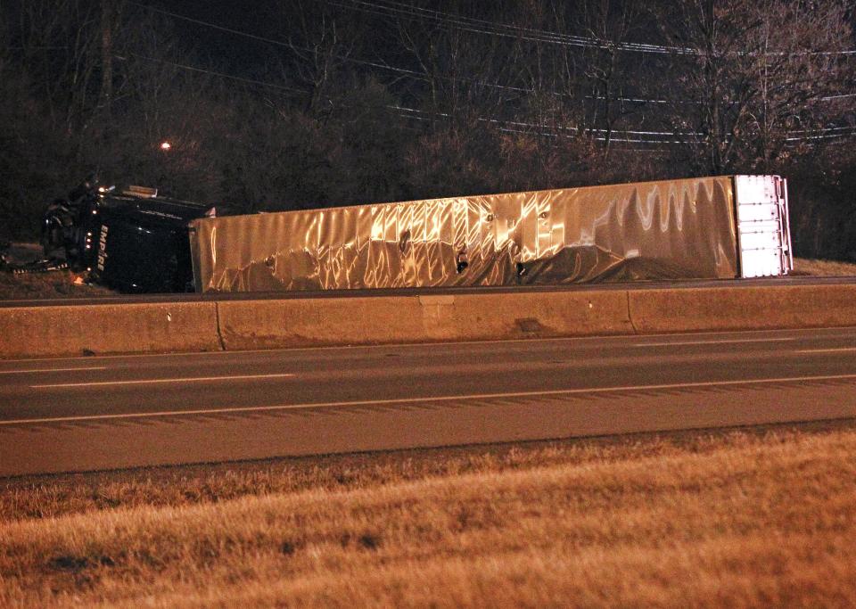 A tractor trailer lies on it's side after Lexington police closed Interstate 75 northbound because of the wreck at I-75 and North Broadway. Hazardous materials teams have been called to the scene as well on Friday Jan. 10, 2014 in Lexington, Ky. (AP Photo/The Lexington Herald-Leader, Mark Cornelison)